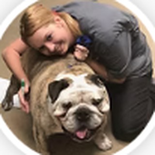 Caitlin hugging a smiling English bulldog